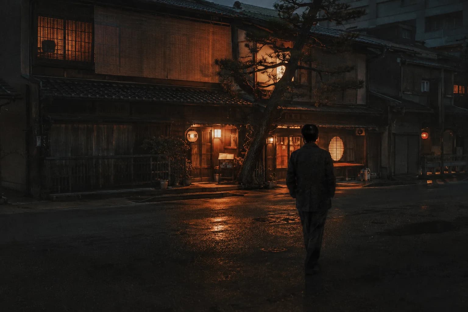 Une ruelle de Kyoto à la tombée de la nuit, éclairée par des lanternes orange.